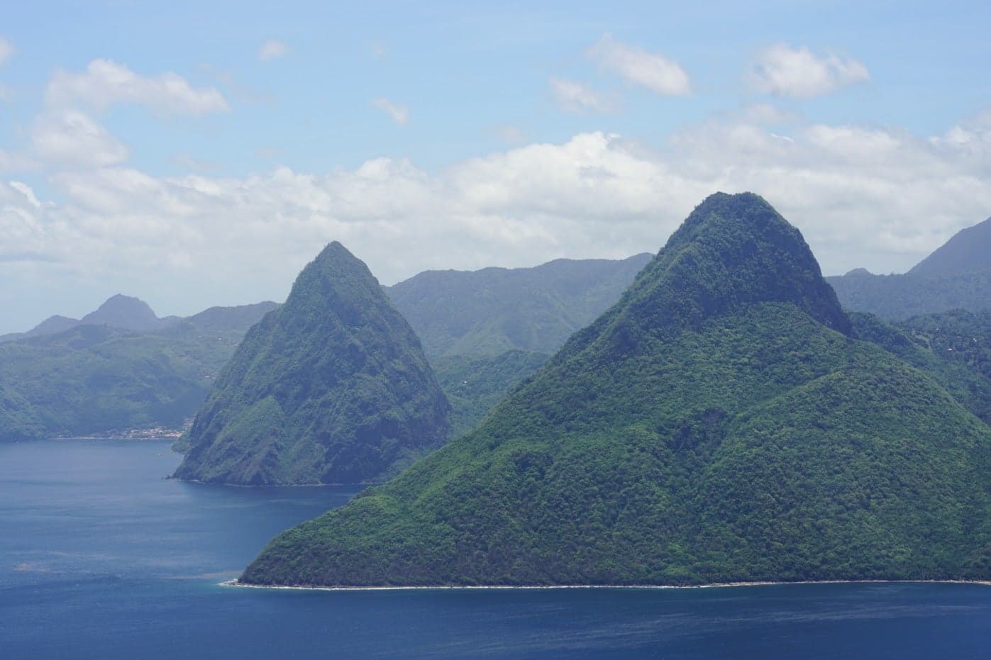 Two dramatic green peaks, the Pitons, rising sharply from the Caribbean Sea