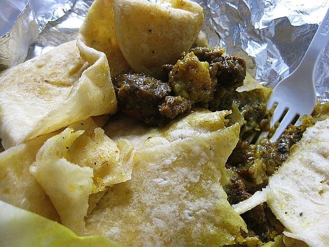 A plate of soft Surinamese roti flatbread served alongside a richly spiced curry