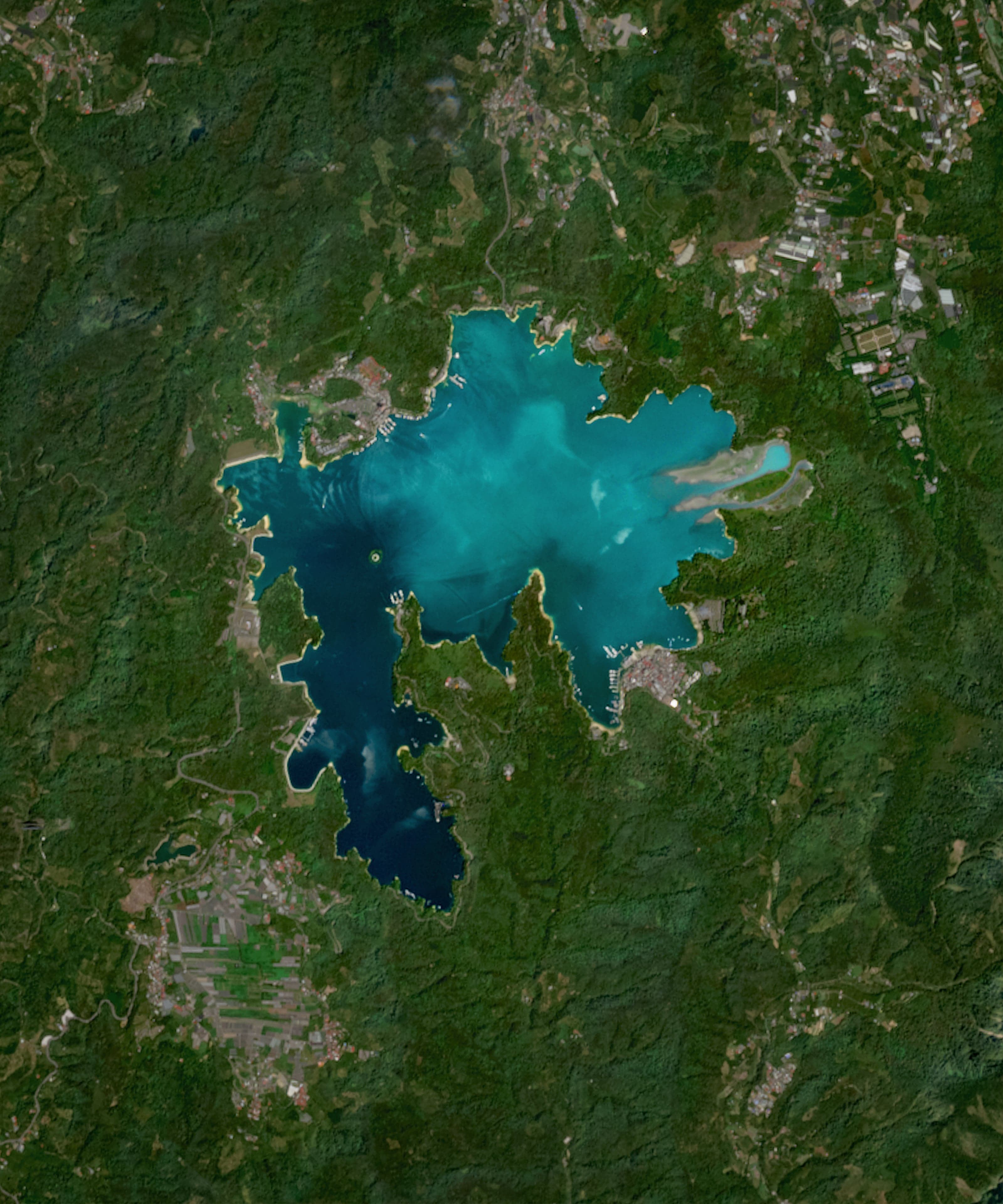 A misty view of Sun Moon Lake surrounded by green mountains